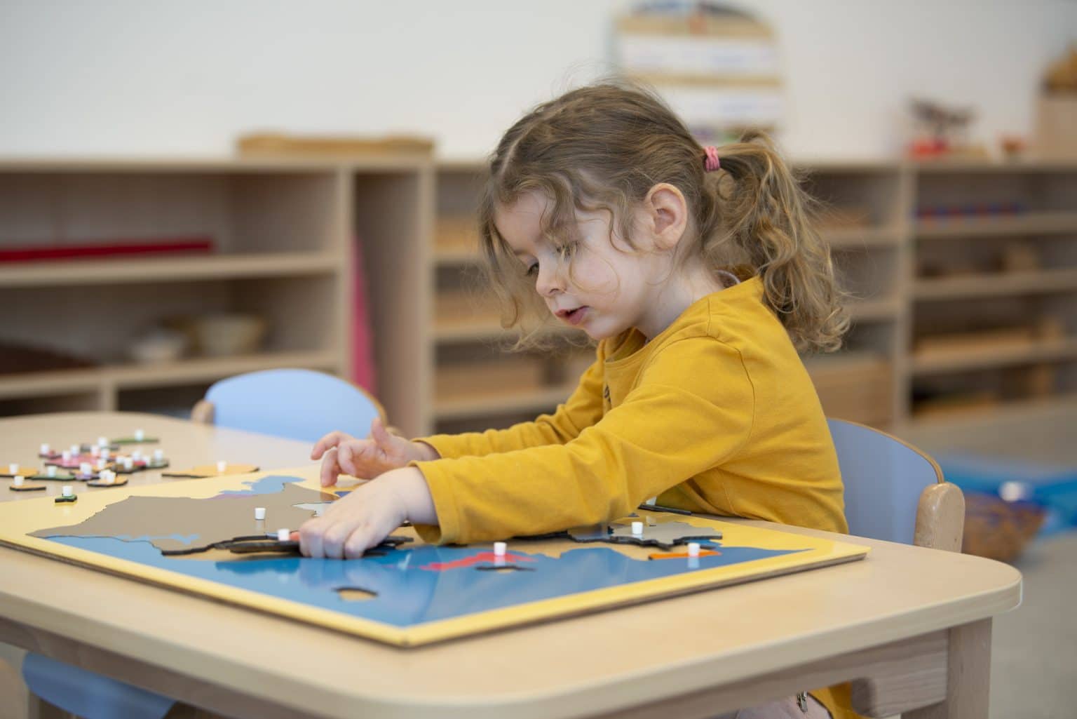 enfant qui fait puzzle montessori en crèche