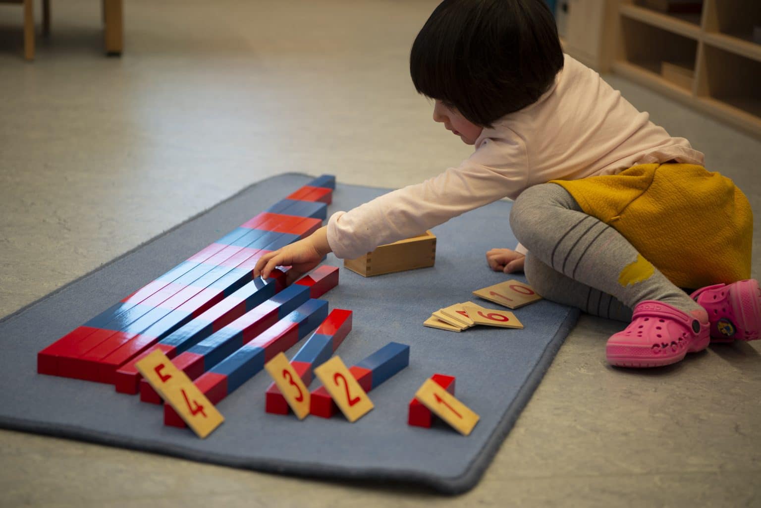 enfant qui joue à un jeu montessori mathématiques en crèche