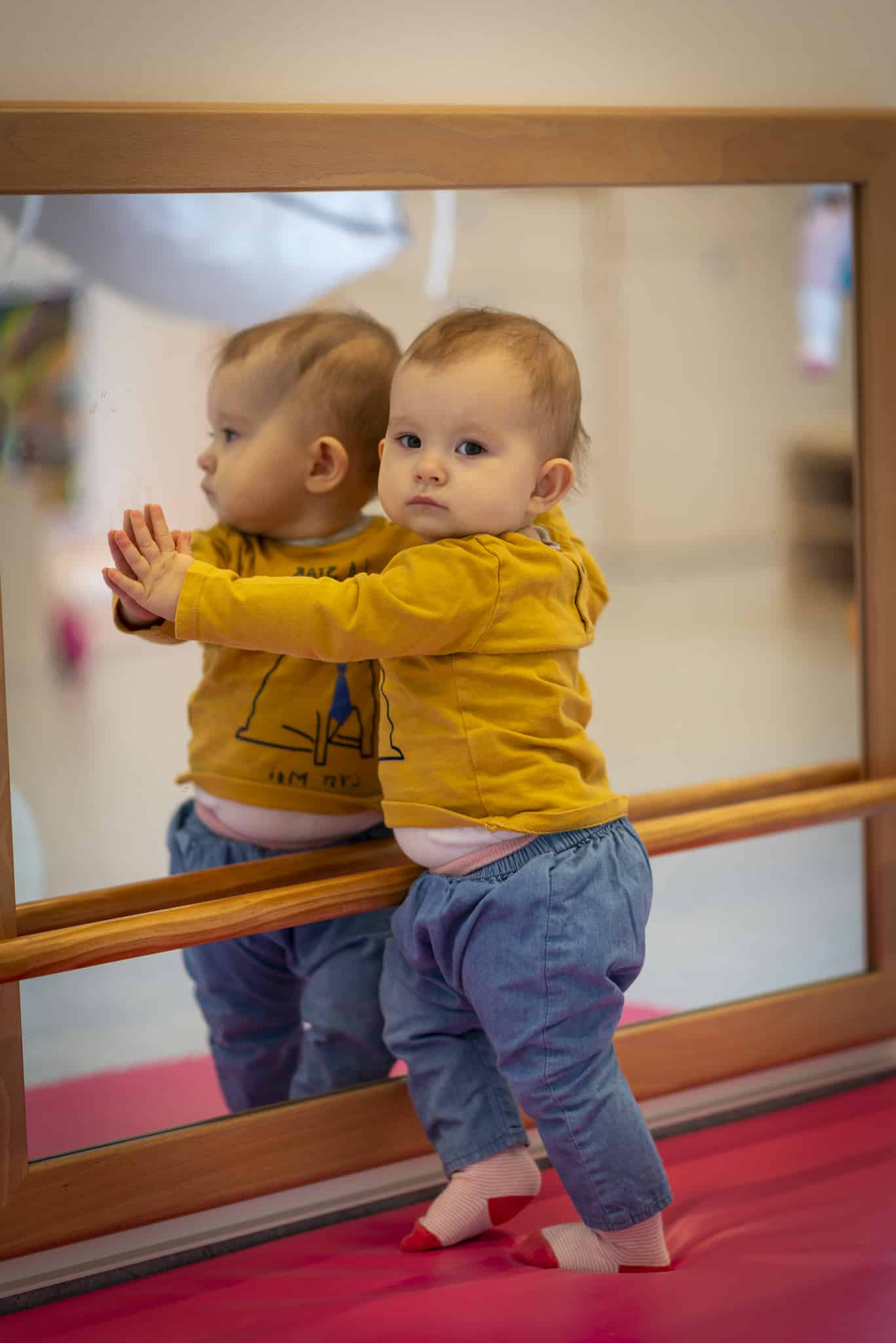 un enfant qui utilise la barre de brachiation en crèche
