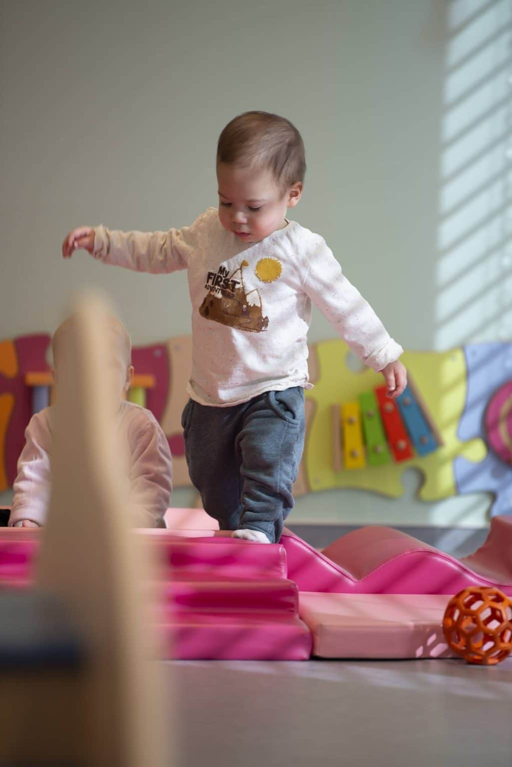 un enfant en apprentissage de la marche en crèche