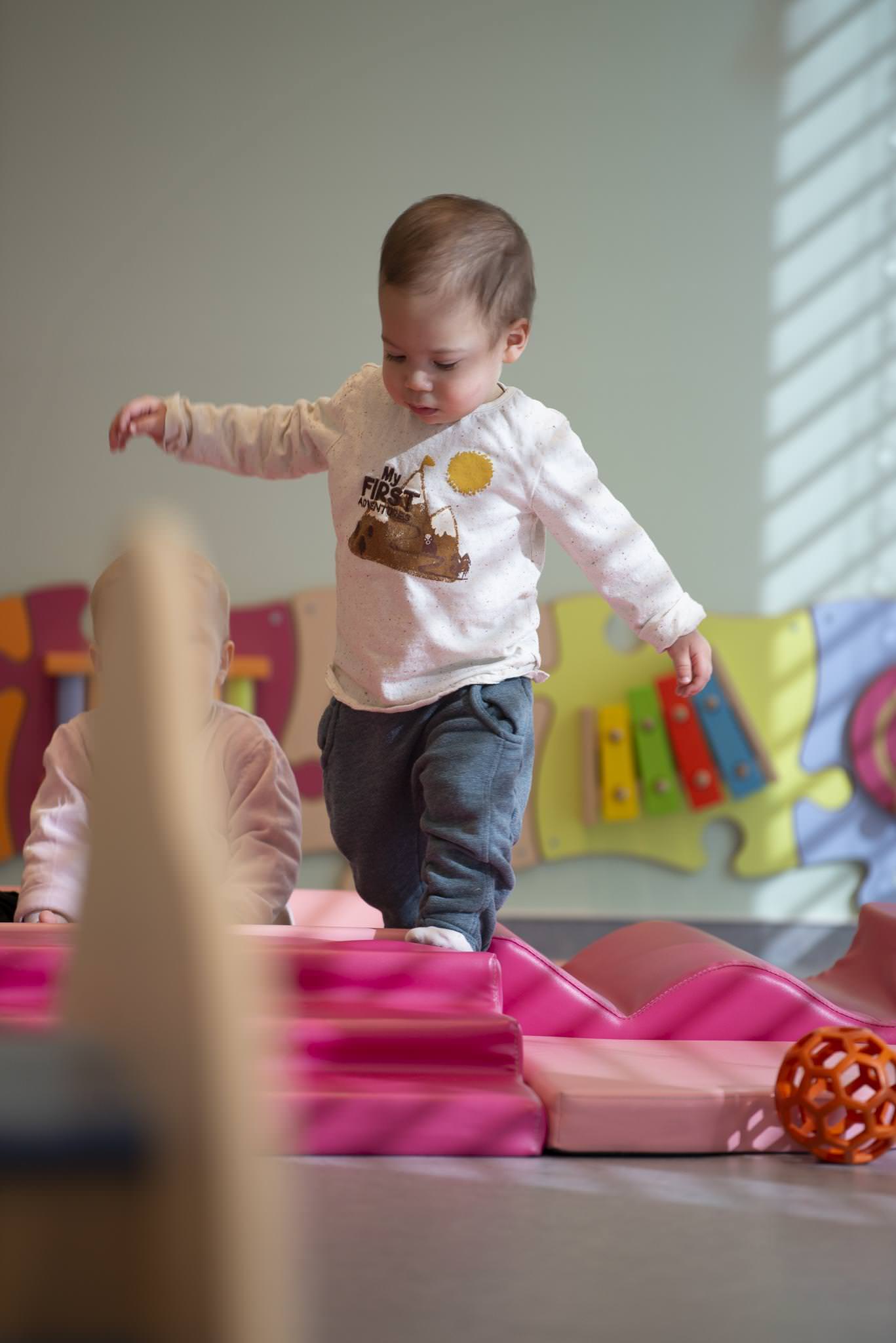 un enfant en apprentissage de la marche en crèche