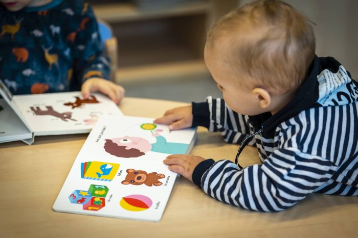 un bébé découvre un livre en crèche