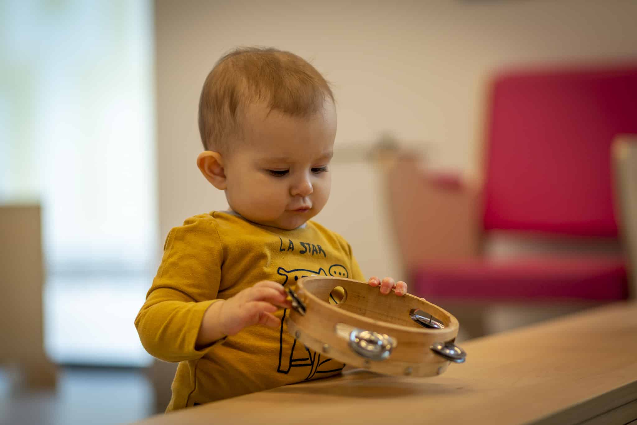 un enfant s'éveille à la musique avec des grelots, en crèche